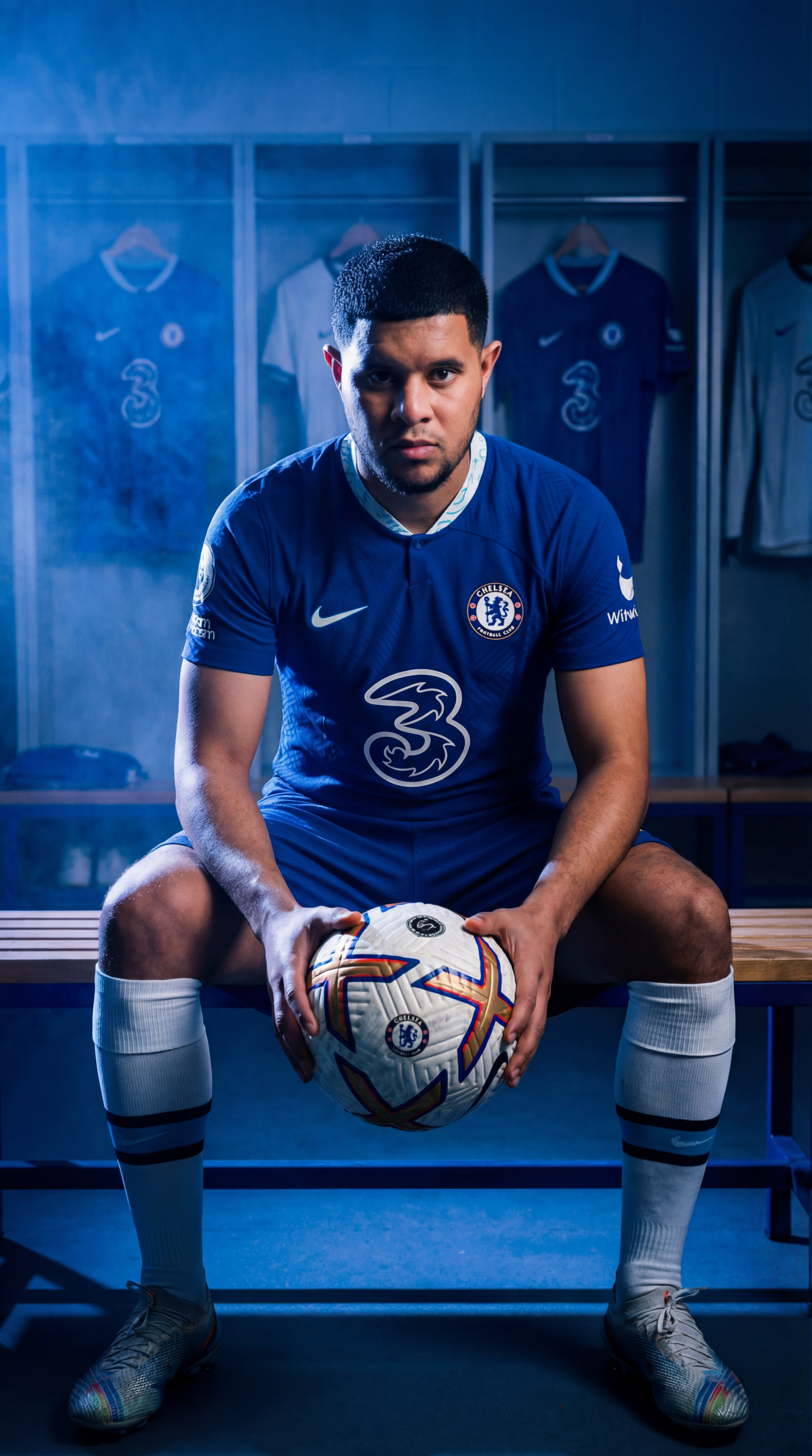 Footballer seated in a dramatic blue stadium scene